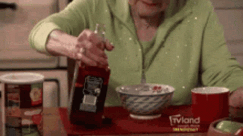 Old Lady Pouring Whiskey Bottle On The Bowl GIF
