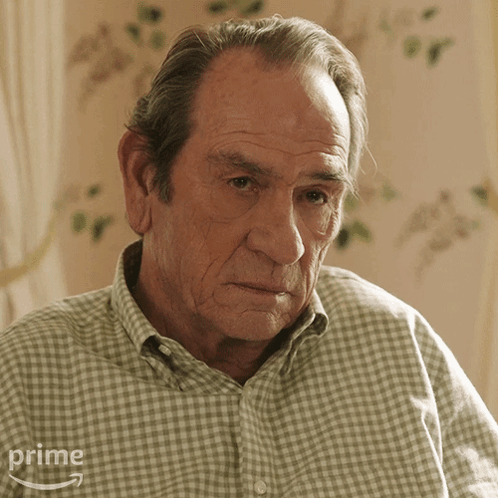Older Man In Plaid Shirt Sitting In Front Of Prime Logo GIF