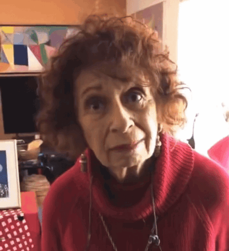 Older Woman in Red Sweater and Earrings Looking