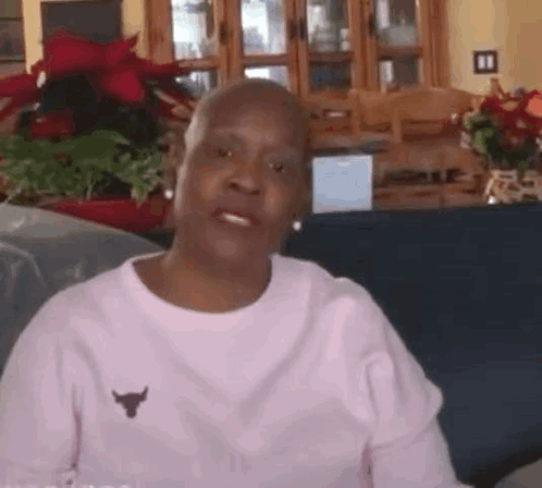 Older Woman Sitting On Couch In Pink Bull Shirt GIF