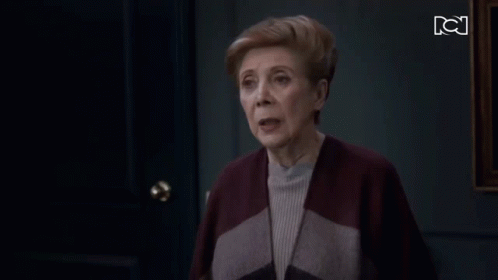 Older Woman Standing in Front of Door With BC