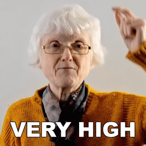 Older Woman Wearing Glasses and Yellow Sweater Says Very High