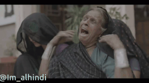 Older Woman With Mouth Open Comforted by Woman in Hijab