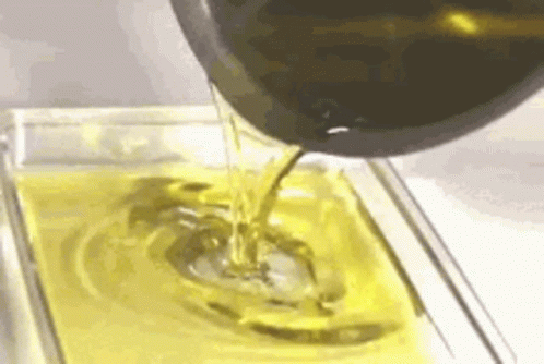 Olive Oil Is Being Poured Into A Glass Dish . GIF