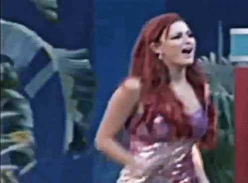 Open-Mouthed Red-Haired Woman in Purple Dress on Stage