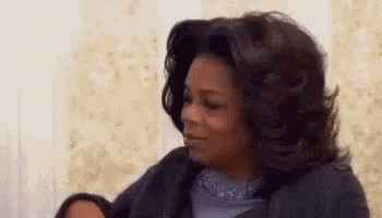 Oprah Winfrey Is Sitting On A Couch With Her Eyes Closed And Making A Funny Face . GIF