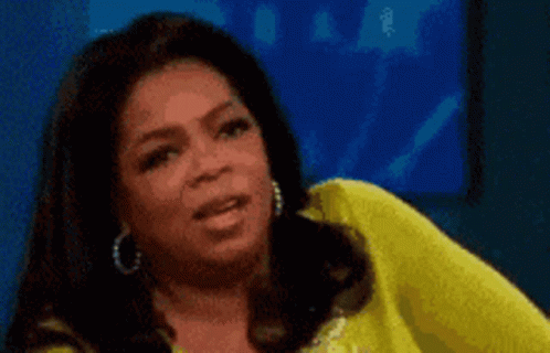Oprah Winfrey Is Wearing A Yellow Shirt And Earrings GIF