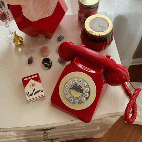 Pack of Marlboro Cigarettes Next to Red Telephone