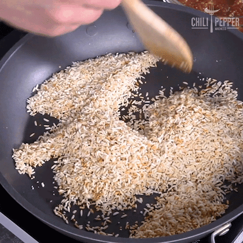 Pan of Rice Stirred With Wooden Spoon From Chili Pepper Markets