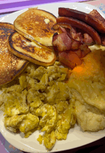 Pancakes Scrambled Eggs Bacon Cheese on White Plate