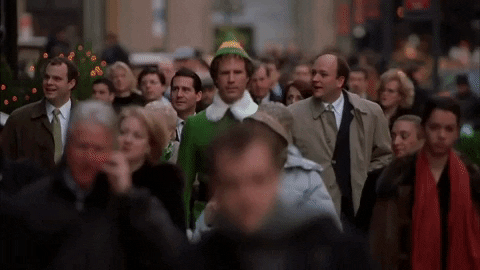 Papa Elf Walking Among The Crowd GIF