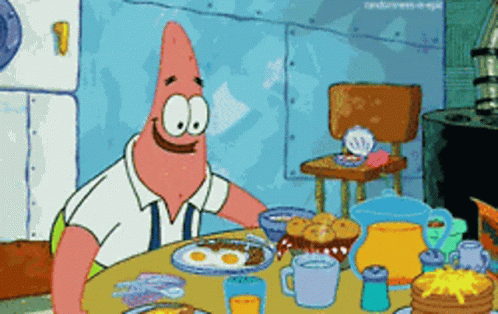 patrick star from spongebob is sitting at a table with a plate of food
