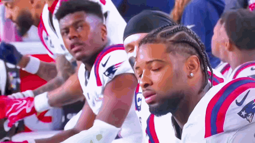 Patriots Football Players Sitting on Sidelines