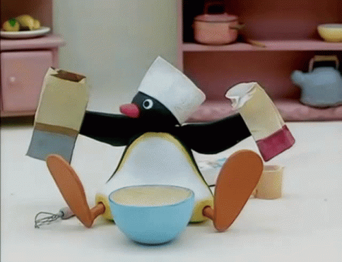 Penguin In Chef Hat Sitting Next To Bowl Of Food GIF