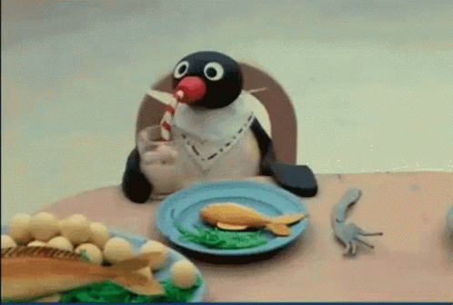 Penguin Sitting at Table with Food and Milkshake