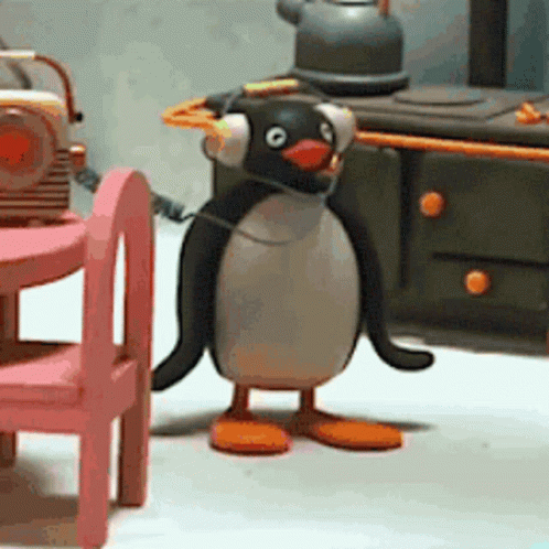 Penguin Wearing Headphones in Front of Radio