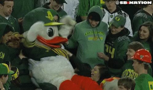 People Around Duck Mascot In Green Hoodie GIF