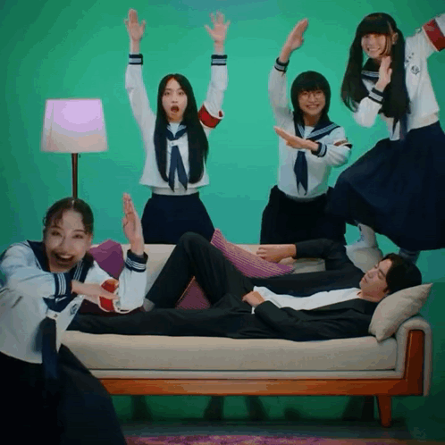 People Around Man on Couch with Arms Up