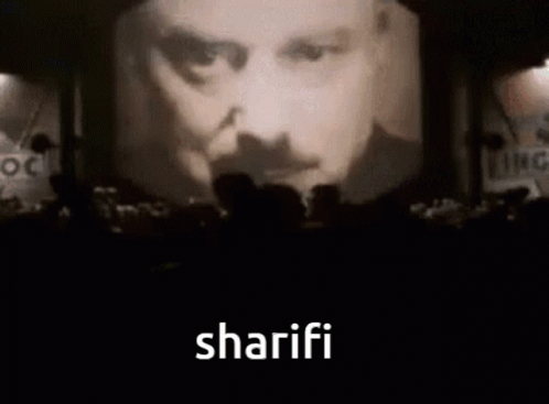 People Before Screen With Man's Face and Sharifi
