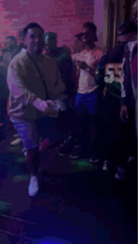 People Dancing in Club with Purple Lights