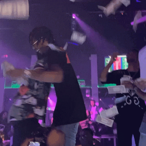People Dancing in Club with Purple Lights