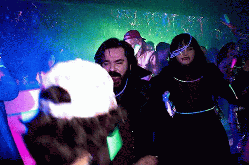 People Dancing in Dark Room with Glow Confetti