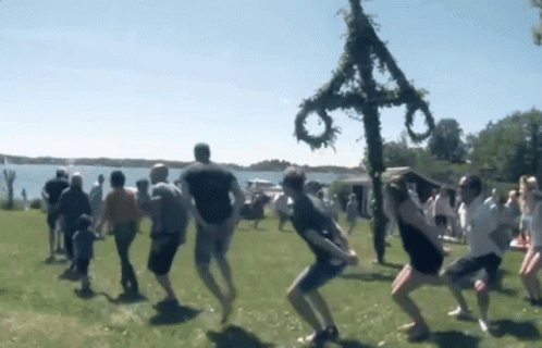 People Dancing In Field Front Of Cross GIF