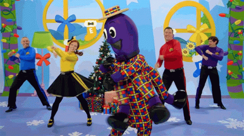 People Dancing In Front Of Christmas Tree Saying E GIF