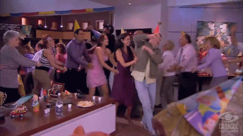 People Dancing in Room With Caragol TV Sign