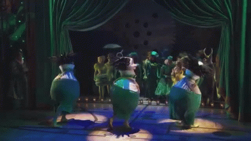 People Dancing On Stage With Green Curtains GIF