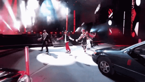 People Dancing On Stage With Parked Car GIF