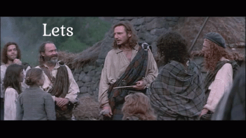 People Gathered Around Man in Kilt Saying Lets