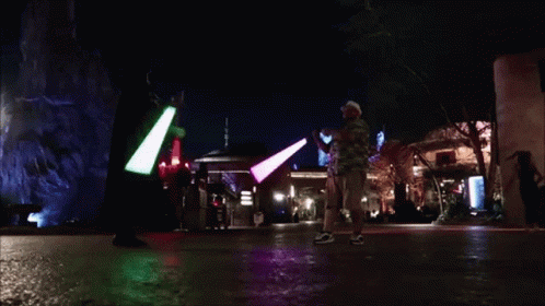People Holding Green and Purple Light Sabers