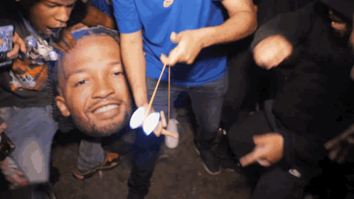 People Holding Man's Head in Air