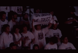 People Holding Sign In Jang We Trust