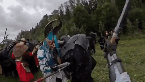 People In Costumes Holding Swords And Shields GIF