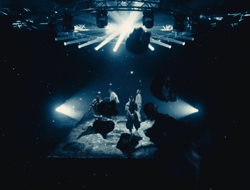 People in Dark Room With Light Through Ceiling