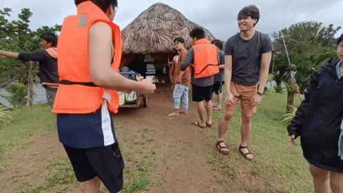 People in Life Jackets Standing in Field