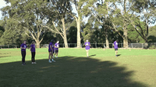 People in Purple Shirts Standing on Grass