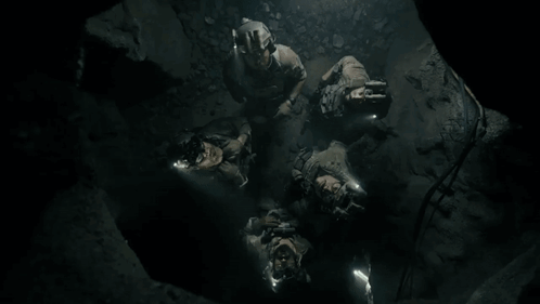 People Lying in Cave Looking Up