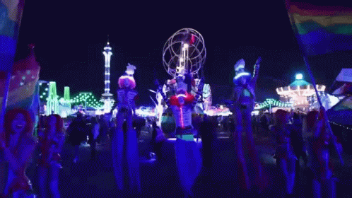 People on Stilts in Front of Carnival Ride