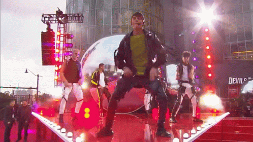 People Performing On Stage In Front Of Building Saying Devil's GIF