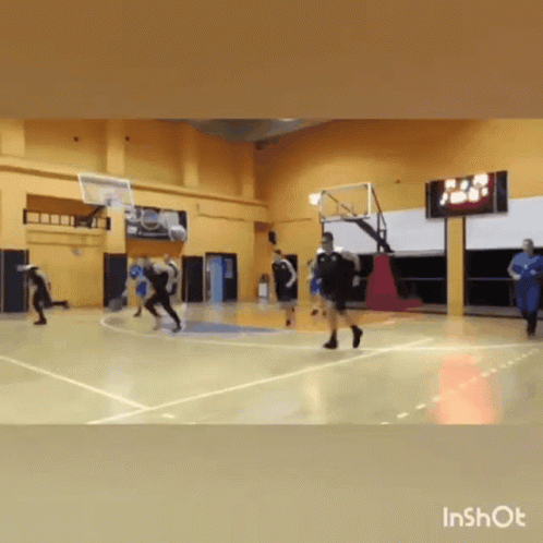 People Playing Basketball on Court with Scoreboard