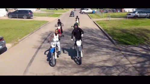 People Riding Dirt Bikes Down Street