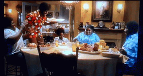 People Sitting Around Food Table GIF