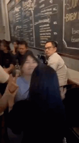 People Sitting at Table in Front of Chalkboard