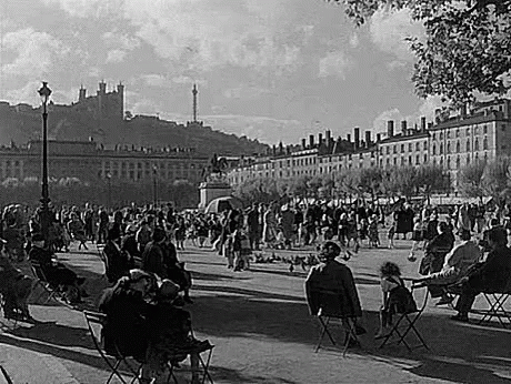 People Sitting at Tables in Park With Castle