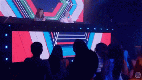 People Sitting in Front of Large Music Video Screen