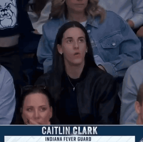 People Sitting in Stadium with Caitlin Clark on Screen