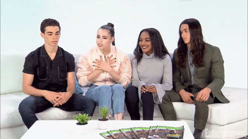 People Sitting On Couch With Entertainment Magazine GIF